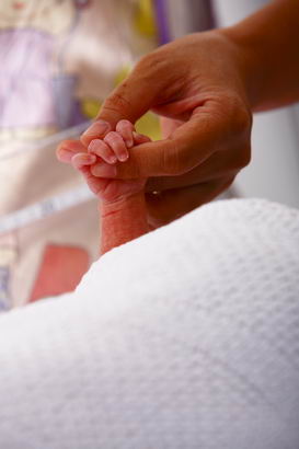 A mother and baby's hands clasped