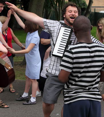 Children and adults play in the school
                  playground