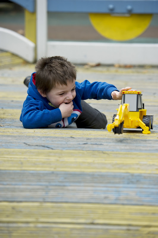 A boy plays with a toy digger