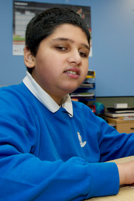 A boy with his teacher reading by
                  touch, using the Moon system