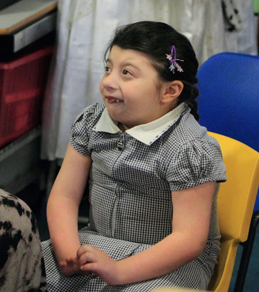 A girl sits opposite her teacher