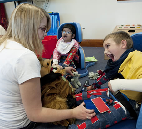 Carer interacting with disabled children.