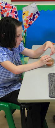 A teacher offers a girl a choice of two
                  objects