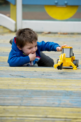 A boy plays with a toy digger