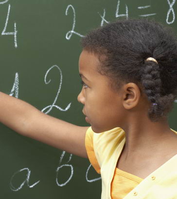 A typically developing young
                  girl uses a blackboard in class
