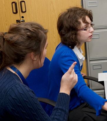 Two teenage girls take a written
                  test