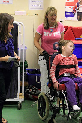 Two carers with child in wheelchair