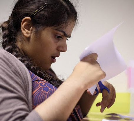 Girl cutting paper with scissors