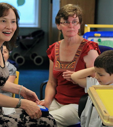 Two women and two children seated in classroom.