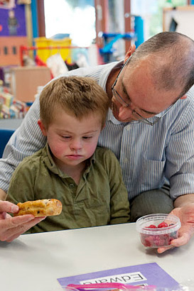 Carer showing boy two items of
                  food.