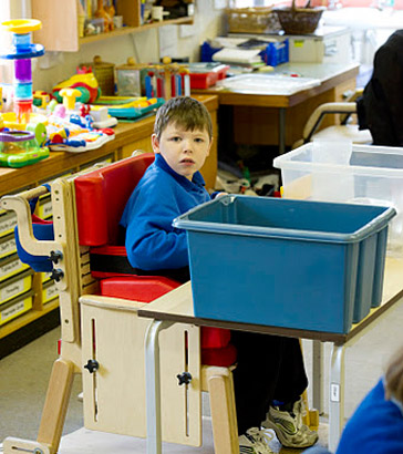 Seated boy looks across classroom.