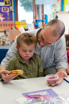 Carer showing boy two items of
                  food