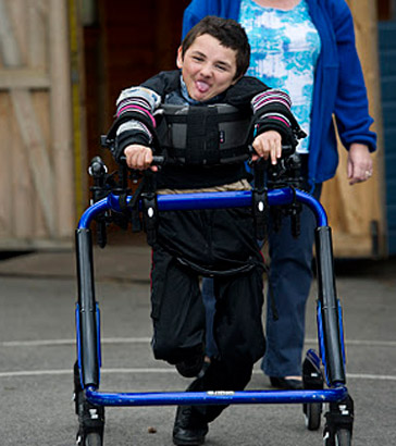 Boy with walking support and carer