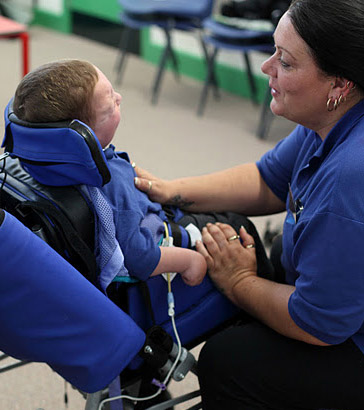 Boy in chair with carer