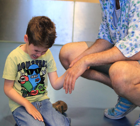 Carer holding distressed boy's hand