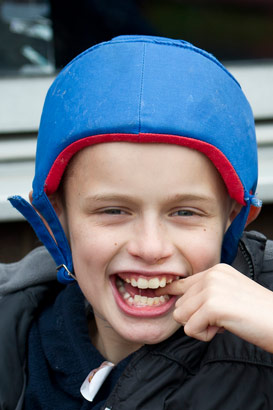 Child with padded headgear enjoys
                  a moment with his carer/teacher