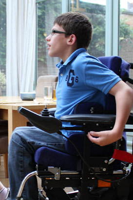 Brother in automated wheelchair talks to his
                  sister in the conservatory of their family home