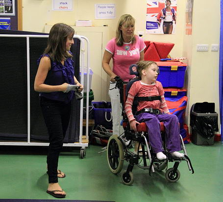Two carers with a child in a wheelchair
