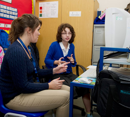 A girl and her teacher at a computer
                  during an English lesson