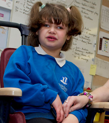 A girl in a specialist chair and
                  a teaching assistant