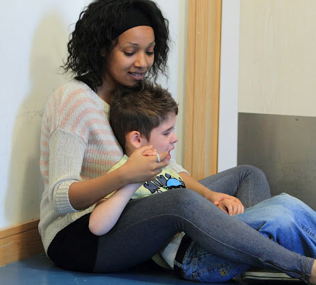 Carer comforting distressed boy