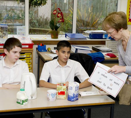 Teacher helping two boys with their lesson