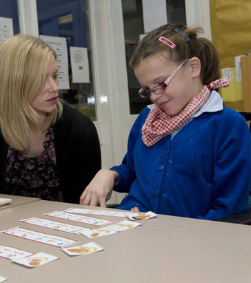 Teacher shows a girl three cards