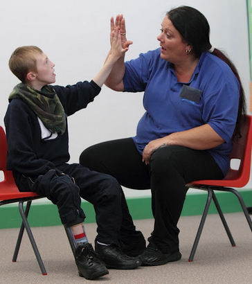 Female teacher and young boy high five