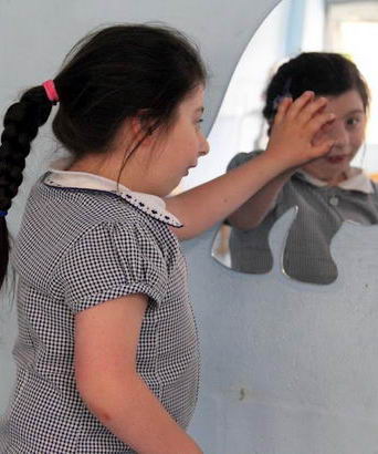 A young girl uses a multi-sensory mirror