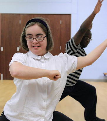 A teenage girl dances in a school gym