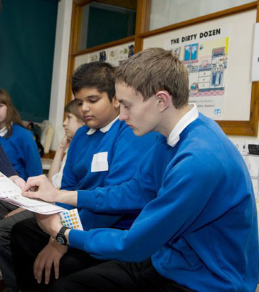 A girl smiles as a teacher sounds a manual
                  'bugle horn