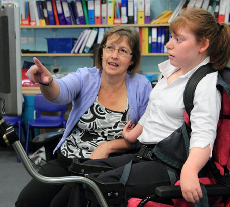 A teacher watches a girl play with a 'slinky'