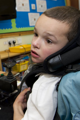 Young boy with supportive ICT
                  equipment sits in front of interactive computer screen