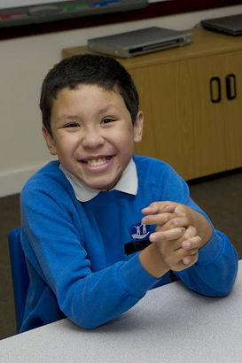 Young boy and female teacher fully
                  engaged at school desk