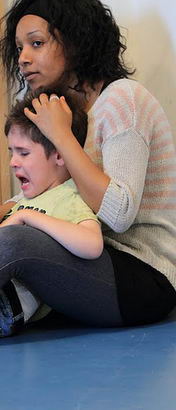 A carer holds a distressed boy