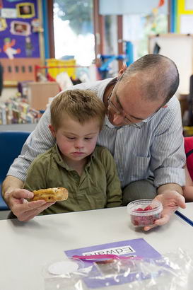 A carer calms a distressed boy