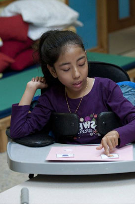A girl chooses a card from her carer