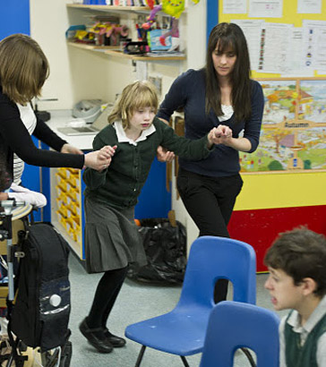 A carer holds an upset boy's hand