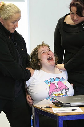 A distressed girl with two carers