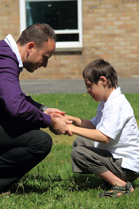 A boy and his carer facing each other