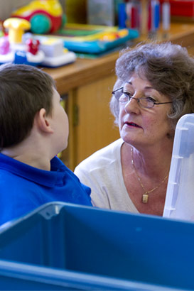 A carer holds an upset boy's hand