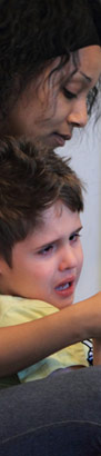 Carer holds a distressed child