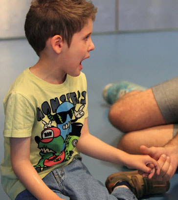 A carer holds an upset boy's hand