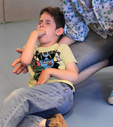 A carer calms a distressed boy
