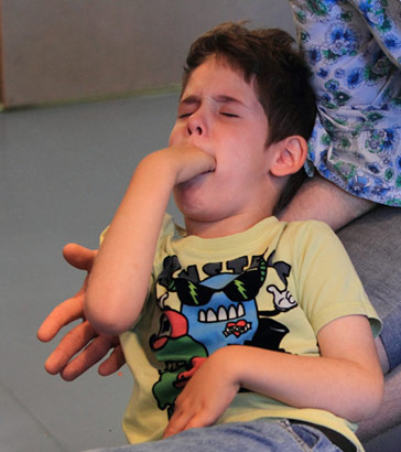 A carer calms a distressed boy