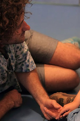 A carer calms a distressed boy
