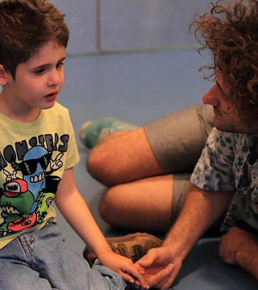 A carer calms a distressed boy