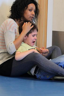 Distressed boy being calmed by a carer
