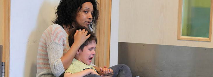 Distressed boy being calmed by a carer