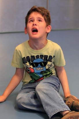 Young boy sitting on floor in classroom